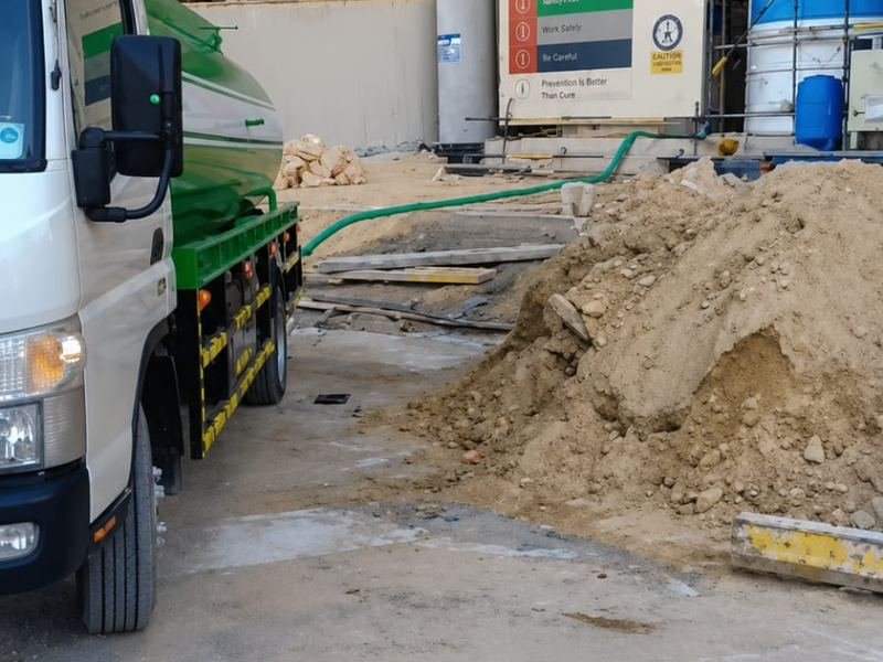 Water tanker truck supplying water at a construction site